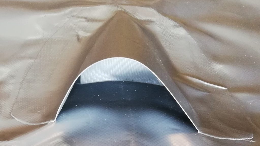 Arched ventilation opening welded into a grey PVC boat cover